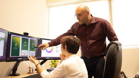 Björn reviewing interface designs with a colleague at a workstation
